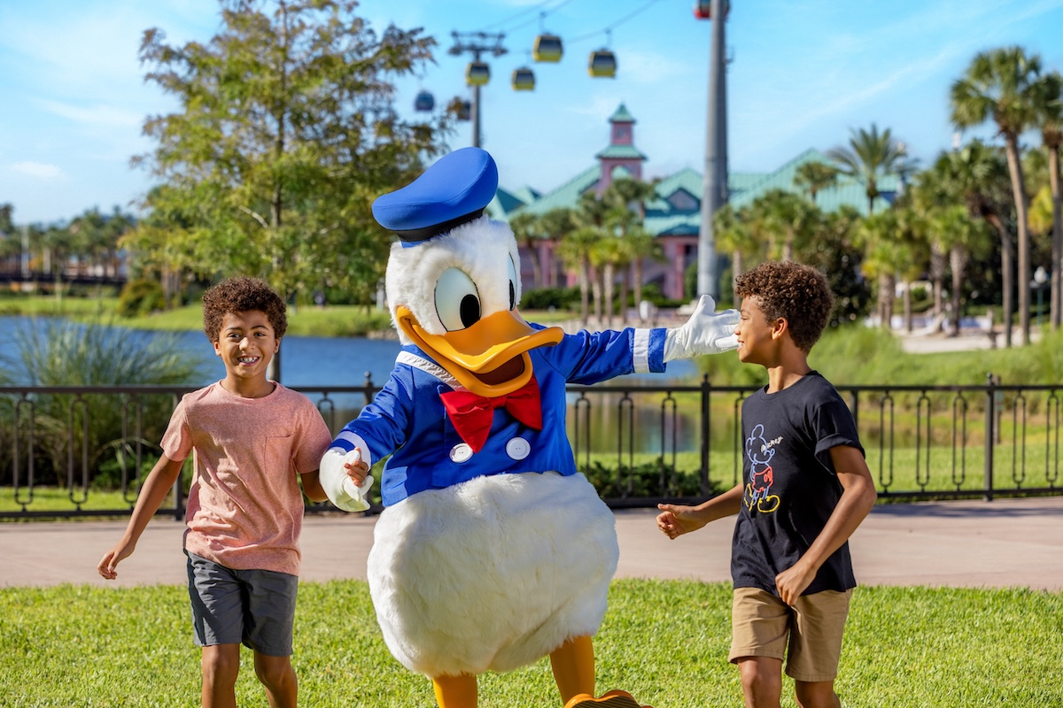 WDW_FY26_Q4_Donald_Caribbean_Beach A smiling mother and two young children happily walk around Disney's Grand Floridian Resort & Spa.